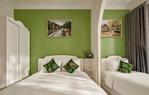 a green room with two beds and two chairs at Chez Mimosa Petite - Free Laundry in Ho Chi Minh City