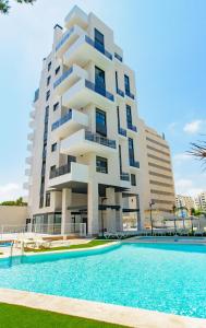 a building with a swimming pool in front of a building at Myflats Campello Beach in El Campello
