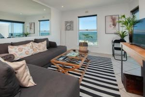a living room with a couch and a table at 49 Whalerock in Hermanus