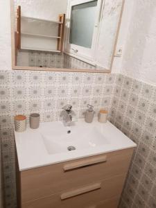 a bathroom with a white sink and a mirror at Chalet au cœur de la montagne jacuzzi privé in Sainte-Marie-de-Campan +19 photos