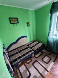 a bedroom with a bed in a green room at 3-х комнатная квартира in Okhtyrka