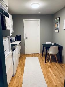a small kitchen with a table and a white rug at Leilighet i Tromsø in Tromsø +8 photos