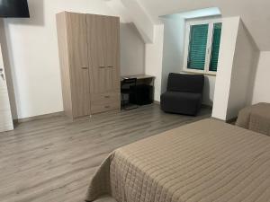 a bedroom with a bed and a desk and a chair at Camera Quadrupla Civitanova Marche in Civitanova Marche