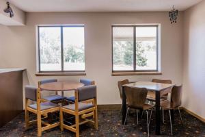 a waiting room with two tables and chairs and windows at Super 8 by Wyndham Madison in Madison