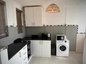 a kitchen with a washing machine and a washer at Stylish unit with amazing view in Hentiesbaai