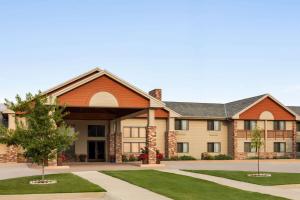 an exterior view of a large building with grass at AmericInn by Wyndham Havre in Havre