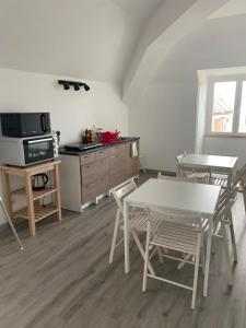 Una cocina con mesa y sillas y un microondas. en DMF Apartments, en Civitanova Marche