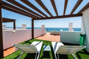 a patio with a table and chairs and the ocean at AlmeriaSuite Mojacar Breeze Apartments in Mojácar