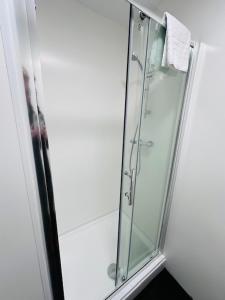 a shower in a bathroom with a glass shower stall at The Wyken Inn in Coventry +19 photos