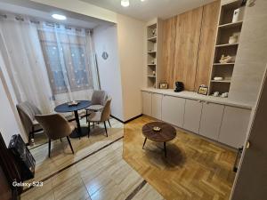 a living room with a table and chairs and a window at Gold Studio in Kragujevac