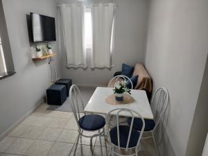 a small living room with a table and chairs at Apartamento com piscina! in Samaritá