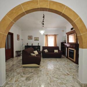 a living room with a couch and an archway at Spacious 4-Bedroom Apartment in Mosta