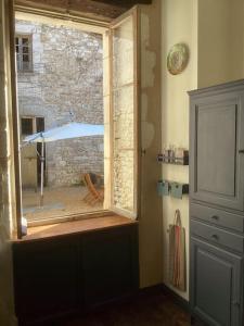 a window in a room with a view of an umbrella at Agréable maison avec jardin dans le centre historique de Bourdeilles in Bourdeilles