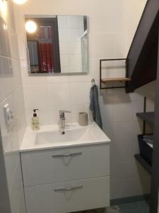 a white bathroom with a sink and a mirror at Agréable maison avec jardin dans le centre historique de Bourdeilles in Bourdeilles
