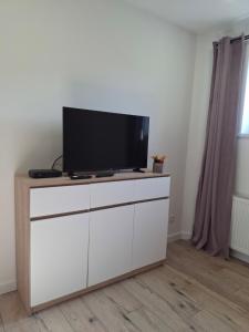 a tv sitting on top of a white dresser at Apartament na Krupie in Krupski Młyn