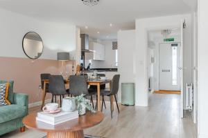 a living room and kitchen with a table and chairs at Stylish & Chic 3 bed House in Cambourne