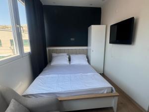 een kleine slaapkamer met een bed en een televisie bij Turap Homes in Antalya
