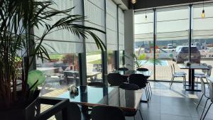 a restaurant with tables and chairs and a large window at Hotel Picaro Kopytkowo A1 in Kopytkowo