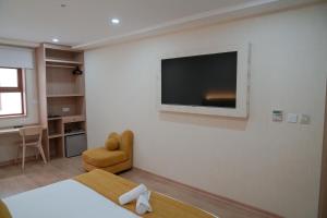 a room with a tv on a wall with a bed at Sahariano hotel City Center in Laayoune