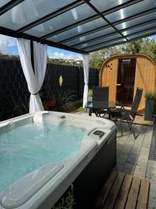 a hot tub in a backyard with a pergola at Spa Cottage Serenity Chalet in Rittersdorf
