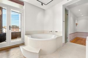 a white bathroom with a tub and a large window at Boutique Hotel Copper & Co in Middelburg +60 photos