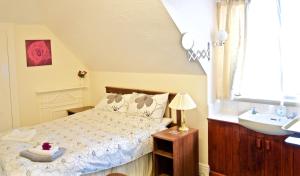 a small bedroom with a bed and a sink at Landguard House Bed Only in Southampton