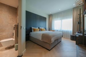 巴德胡弗多普Boutique Hotel Herbergh Amsterdam Airport FREE PARKING的一间卧室，配有一张大床和一扇大窗户。