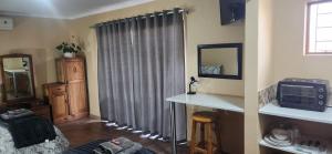a living room with a gray curtain and a microwave at Prieska Kokerrus in Prieska