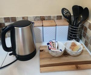 a coffee pot on a counter with a wooden cutting board at Prieska Kokerrus in Prieska