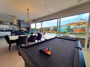 a pool table in the middle of a living room at Casa de Verão no Malibu à Beira do Lago in Xangri-lá