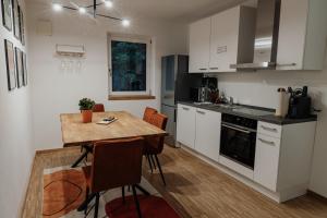 a kitchen with a wooden table and a kitchen with white cabinets at Passaus Motto Appartements! Solo - Pärchen - Familien - Gruppen in Passau