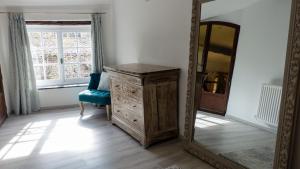 a mirror and a wooden dresser in a room at Gîtes de Montcabirol - Malepère in La Bastide-de-Bousignac