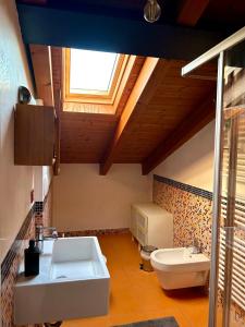 Un baño con lavabo, inodoro y ventana. en BikeBnB, en Mira