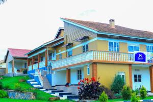 a yellow and blue building with steps in front of it at Hakyiri B&B in Kabale