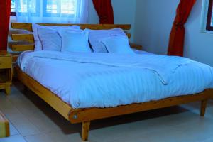 a bed with blue sheets and blue pillows at Hakyiri B&B in Kabale +20 photos