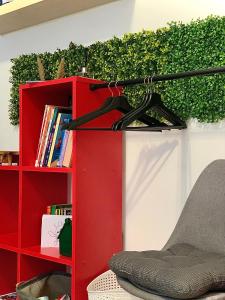 a red book shelf with a chair next to a red bookcase at Le repaire des héros 150m plage parking privé - lesvoyagescolorés in Saint-Valéry-en-Caux