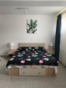 a bedroom with a bed with a pink flamingos blanket at Pensiunea Floris in Vaţa de Jos +22 photos