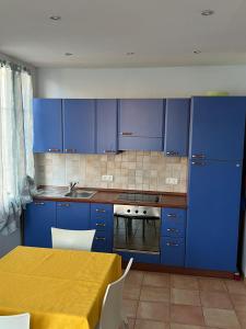 a kitchen with blue cabinets and a table with a yellow table at Rue HENRY BENNET in Menton
