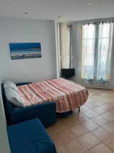a bedroom with a bed and a couch and windows at Rue HENRY BENNET in Menton