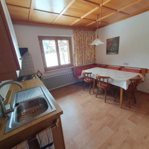a kitchen and dining room with a table and a sink at Haus Salzmann in Sankt Gallenkirch +22 photos