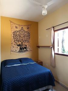 a bedroom with a blue bed and a tapestry on the wall at Refúgio São Tomé in São Thomé das Letras