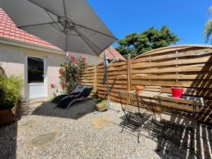 GambaisにあるLE NID - Charmante petite maison avec balnéoのパティオ(傘、ベンチ、フェンス付)