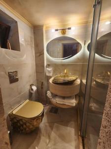 a bathroom with a toilet and a sink at Jay GuestHouse in Fad‘ūs