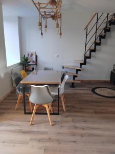 a dining room with a table and chairs and stairs at La grange aux animaux in Tollevast