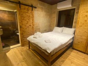 a bedroom with a bed with towels on it at Jay GuestHouse in Fad‘ūs +4 photos