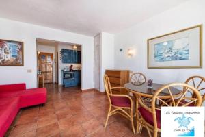 a living room with a table and a red couch at La Caytispa in Puerto de Mogán