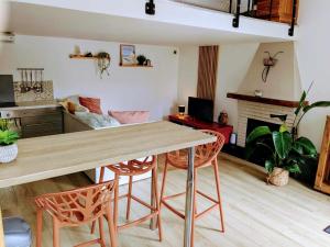 a living room with a wooden table and chairs at Maisonnette centre de Wimereux, parking gratuit, 200m plage in Wimereux