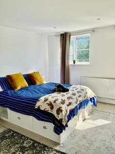 a bedroom with a bed with a blue comforter at Family Home in Seaside Town in Hastings