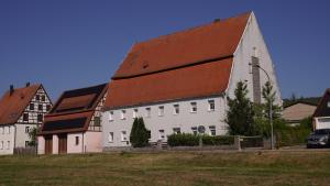 a large white barn with a red roof at Ferienwohnungen Hopfenhaus in Spalt