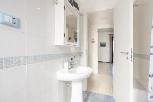 a white bathroom with a sink and a mirror at Villa Le 2 Palme in Isola delle Femmine +26 photos